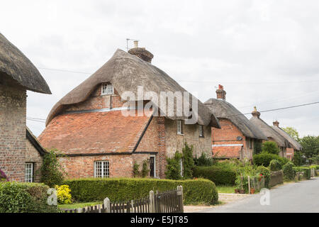 In mattoni tradizionali cottage con il tetto di paglia in Oriente Stratton, un piccolo paese di campagna vicino a Winchester, Hampshire, Regno Unito Foto Stock