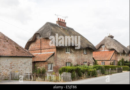 In mattoni tradizionali cottage con il tetto di paglia in Oriente Stratton, un piccolo paese di campagna vicino a Winchester, Hampshire, Regno Unito Foto Stock