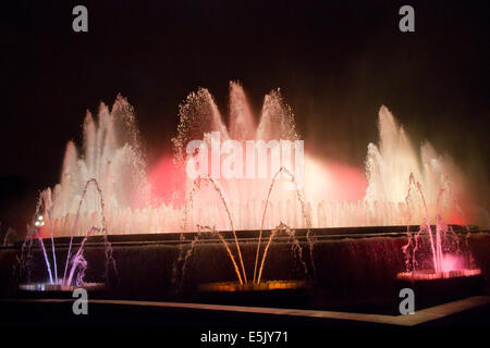 La Fontana Magica di Montjuic, situato al di sotto del Palau Nacional sulla collina di Montjuic e Barcellona di notte Foto Stock