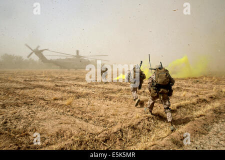 Marines americani con il Primo Battaglione, 7° Reggimento Marine sprint attraverso un campo di carico su una CH-53E Super Stallion elicottero dopo tre giorni di missione Luglio 6, 2014 in Gereshk, provincia di Helmand, Afghanistan. Foto Stock