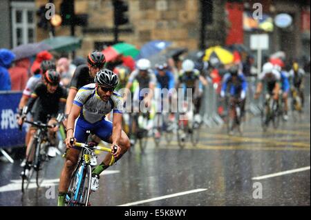 Gara di concorrenti in condizioni dure compresi heavy rain nella loro battaglia per una medaglia nel giorno finale sui giochi del Commonwealth a Glasgow Foto Stock