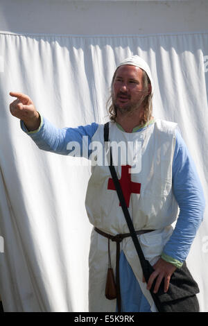 Beeston, Cheshire, Regno Unito 3 agosto 2014. William Freeman di Bolsover, cavaliere dei Templer medievali al Torneo che si tiene al Castello di Beeston, indossa un'infermiera maschile uniforme Medica medievale in costume speciale. Historia Normanni un medico medievale del 12 ° secolo all'evento di gruppo di rievocazione. Foto Stock