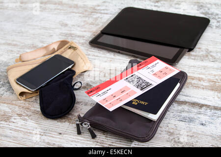 Biglietto aereo, un passaporto in corso di validità e di elettronica, prepararsi al viaggio Foto Stock