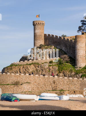 Rocca di Tossa de Mar sormontato da una bandiera della Catalogna, barche al di sotto. La pietra di massicce mura difensive e torre di questo punto di riferimento Foto Stock