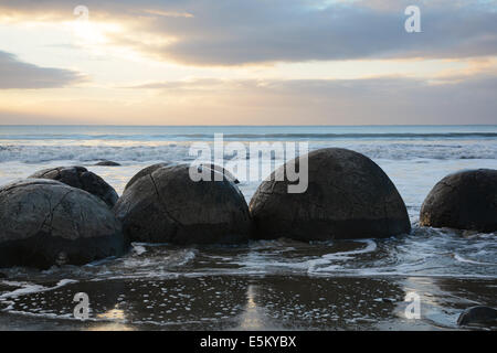 Tramonto sulla spiaggia di Koekohe e i massi Moeraki Foto Stock