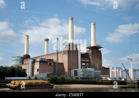 Battersea Power Station visto dal fiume Tamigi con un battello carico di contenitori di rifiuti nella parte anteriore Foto Stock