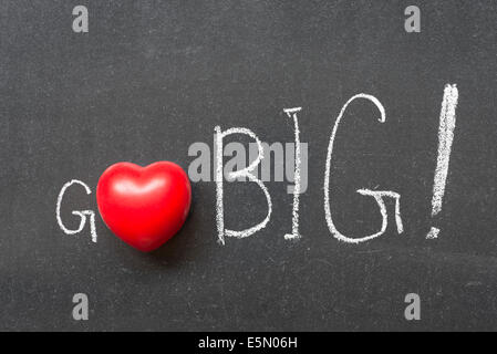Go Big esclamazione manoscritta su lavagna con il simbolo del cuore di invece di o Foto Stock