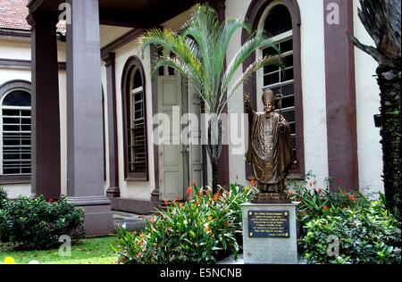SINGAPORE: una statua in bronzo di Papa Giovanni Paolo II si trova in un giardino presso la Cattedrale di 1843-47 del Buon Pastore Foto Stock