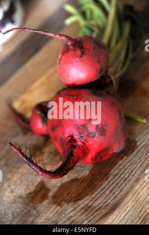 Non cotte barbabietola rossa pronta per la cottura su un tagliere di legno Foto Stock