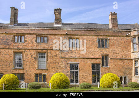 Mattone rosso sul ciglio della strada facciata a Canons Ashby, vicino a Daventry, Inghilterra, un palazzo costruito durante il regno di Elisabetta I (XVI Foto Stock