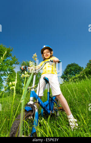 Bambina in maglietta gialla su una bici Foto Stock