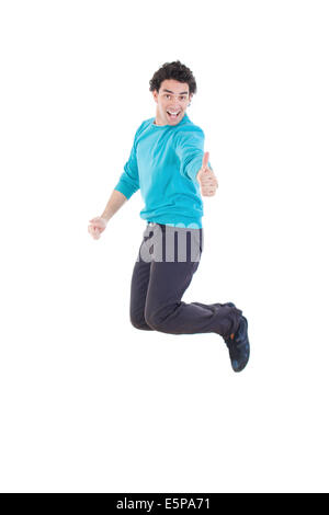 Allegro giovane uomo informale salti in aria che mostra il pollice fino a sorridere, eccitato moderno uomo bello salta fuori di gioia piena di energia Foto Stock