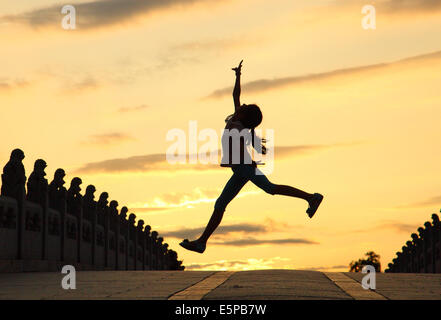 Pechino, Cina. Il 4° agosto 2014. Una giovane ragazza danze sull'diciassette il ponte di Arco nel palazzo d'Estate a Pechino, capitale della Cina, e il Agosto 4, 2014. © Tong Guangping/Xinhua/Alamy Live News Foto Stock