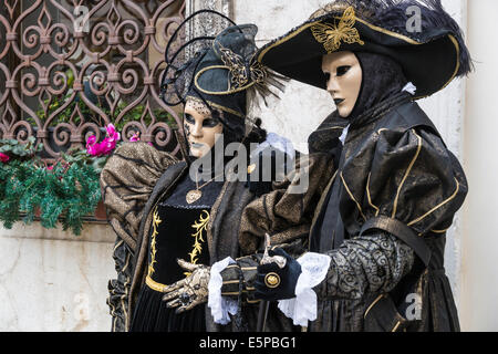 Matura in elaborare stilizzata costumi settecenteschi di nero con oro a San Zaccaria Piazza durante il Carnevale di Venezia. Foto Stock