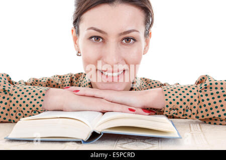 Bella donna in camicia appoggiata sul libro e guardando dritto nella telecamera Foto Stock