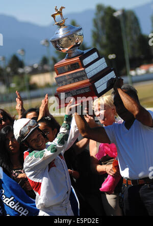 Vancouver, Canada. Il 4° agosto 2014. Jockey Amadeo Perez (L anteriore) celebra la vittoria nella gara su Wilo Kat durante il 2014 BC Cup horse racing a Hastings Park Racecourse a Vancouver in Canada, e il Agosto 4, 2014. È uno del Canada il più grande Best purosangue in gara 6 picchetti grandi gare del valore di oltre $ 300.000 in prizing. Credito: Sergei Bachlakov/Xinhua/Alamy Live News Foto Stock