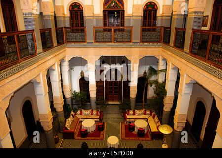 Riad Myra,bellissima scolpiti in stucco di pannelli di cedro,archi,pavimenti in pietra con intricati mosaici,Fontana centrale,tetto,Fez,Marocco Foto Stock