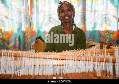 Donna gentile lavorando su un lato del telaio di tessitura su un progetto sociale nelle Highlands di Eritrea, Africa Foto Stock