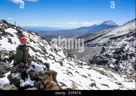 Donna sul Monte Ruapehu guardando verso il Monte Ngauruhoe, parco nazionale di Tongariro, sito UNESCO, Isola del nord, Nuova Zelanda Foto Stock