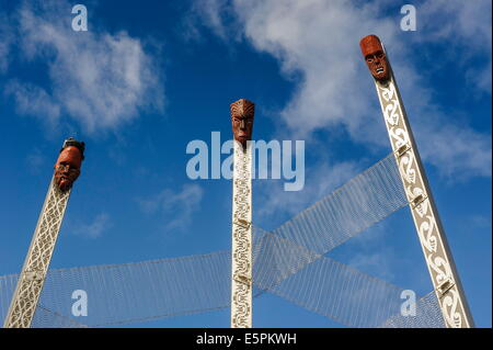 In legno scolpiti sulla maschera enormi cumuli all'ingresso di Te Puia Maori centro culturale, Rotorura, Isola del nord, Nuova Zelanda Foto Stock