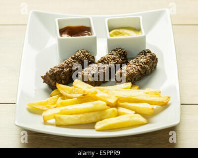 Tradizionale rumena polpette alimentare Mici e patate fritte con Ketchup e Senape Foto Stock