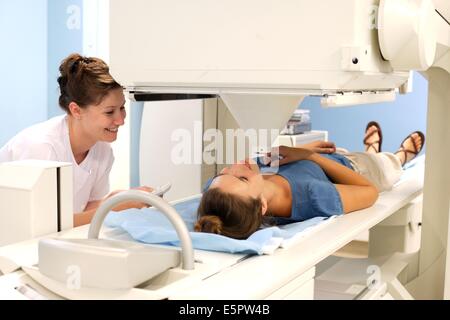 Giovane donna subendo una gamma di esame di scansione della tiroide presso il dipartimento di medicina nucleare, Angouleme Ospedale, Foto Stock