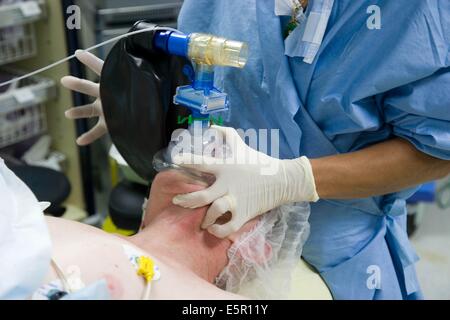 Paziente sotto anestesia generale, con assistenza respiratoria maschera. Foto Stock