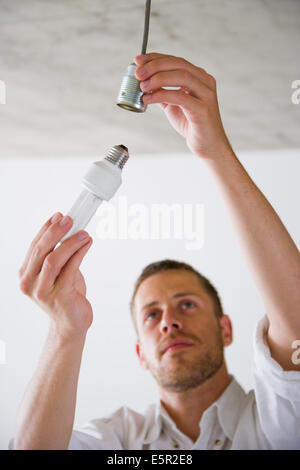 L'uomo cambiare una lampadina. Foto Stock