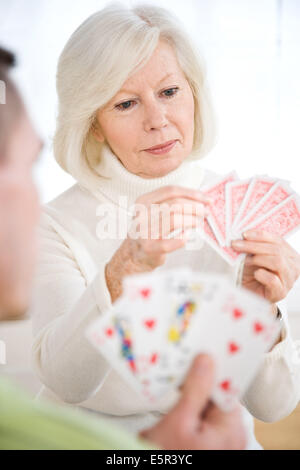 Donna anziana giocando a carte. Foto Stock