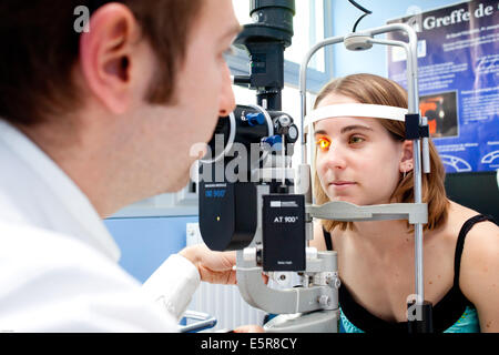Paziente affetto da cheratocono, Il ophtalmologist controlla se il paziente è in grado di adattarsi alle lenti a contatto mediante un oftalmoscopio, Foto Stock