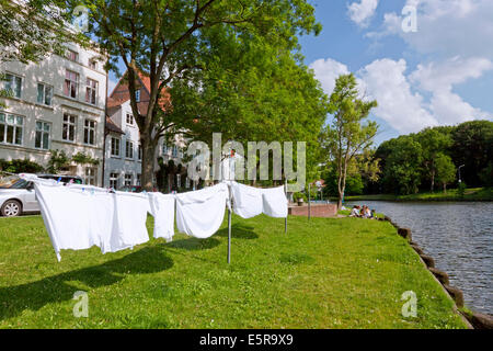 Servizio lavanderia essiccazione nel vento lungo il fiume Trave a Obertrave nella città anseatica di Lubecca, Schleswig-Holstein, Germania Foto Stock