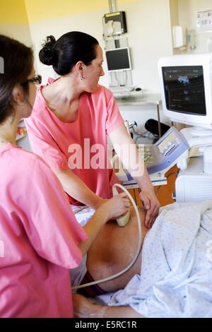 Donna in fase di monitoraggio fetale dopo un'ostetrica appena eseguito una versione, una procedura di ostetricia in cui la posizione Foto Stock