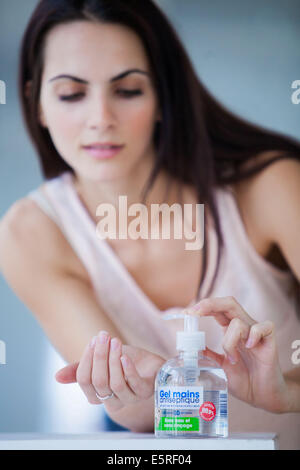 Donna lavando le mani con gel idroalcoolico. Foto Stock