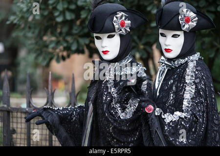 2 Donne in identiche stilizzata costumi settecenteschi di nero con argento dalla chiesa di San Zaccaria durante il Carnevale di Venezia. Foto Stock