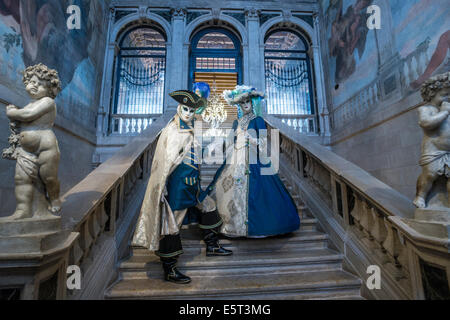 Matura in stilizzata costumi settecenteschi pongono sulla scalinata del palazzo storico durante il Carnevale di Venezia. Foto Stock