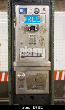 Un abbandonato a gettone telefono pubblico a pagamento su una stazione della metropolitana piattaforma in New York Foto Stock