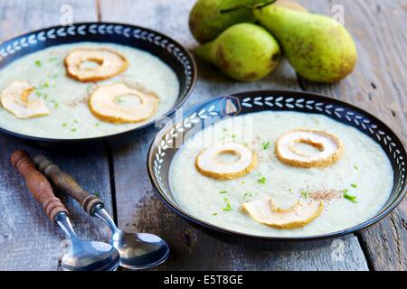 Una caduta cremosa zuppa di stagione con le pere e le radici di sedano, guarnita con secchi in anelli di mela. Foto Stock