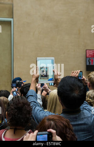 I turisti a scattare foto di Mona Lisa pittura nel museo del Louvre a Parigi, Francia Foto Stock