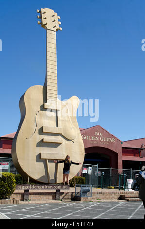 Una signora giovane turista in posa davanti alla grande Golden Guitar, Tamworth Australia Foto Stock