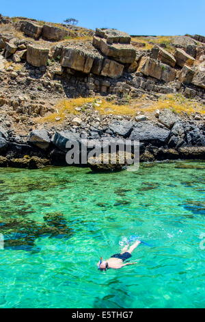 L uomo lo snorkelling nelle acque limpide del telegrafo isola in Khor ash-sham fiordo, Musandam, Oman, Medio Oriente Foto Stock