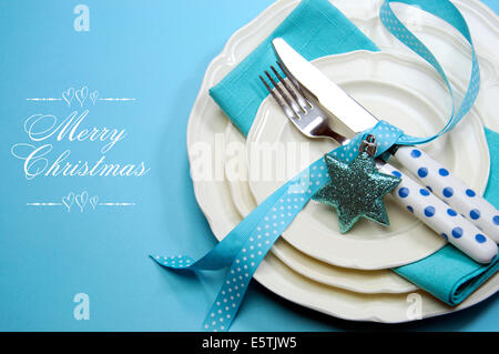 Aqua blue Merry Christmas tavolo da pranzo luogo impostazione con belle cina e polka dot posate su sfondo blu con una copia dello spazio. Foto Stock