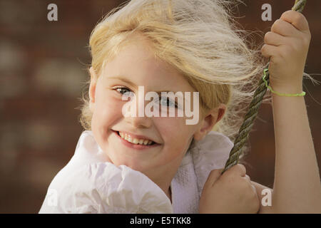 Bella ragazza bionda su uno swing Foto Stock