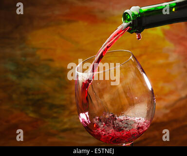 Il vino rosso è versata nel bicchiere di vino Foto Stock