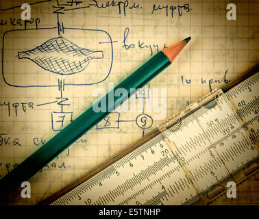 Matita e una slitta regola sulla vecchia pagina con i calcoli di meccanica Foto Stock