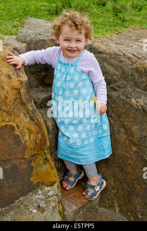 Due anno vecchia ragazza in un abito, sorridente Foto Stock