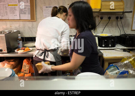 Il personale dei lavoratori in cucchiaio di grasso Cafe facendo colazione Foto Stock