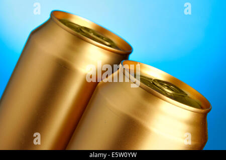 Golden lattine di birra close-up su sfondo blu Foto Stock