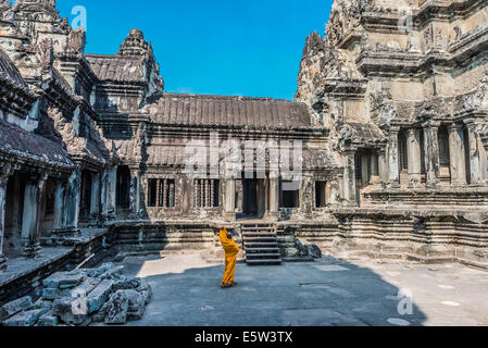 Angkor, Cambogia - Gennaio 1, 2014: un monaco buddista nel cortile del tempio di Angkor Wat Cambogia il 1 gennaio, 2014 Foto Stock