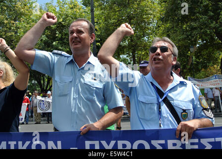 Atene, Grecia. 6 agosto 2014. Poliziotti di sollevare il pugno in rabbia mentre urlando anti-governo slogan.I membri del pubblico greco forze di sicurezza (polizia e vigili del fuoco-coast guard) organizza una manifestazione contro il governo greco i piani di riforma delle loro pensioni e benefici. Credito: George Panagakis/Pacific Press/Alamy Live News Foto Stock