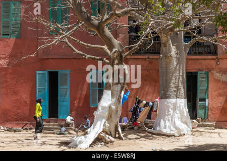 Scena di strada con i bambini che giocano e lavano asciugando, Goree Island, sito UNESCO al largo di Dakar, Senegal Foto Stock